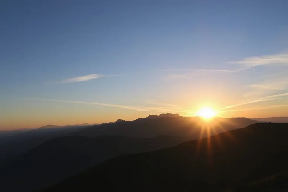 Um amanhecer sobre montanhas, simbolizando novos começos.