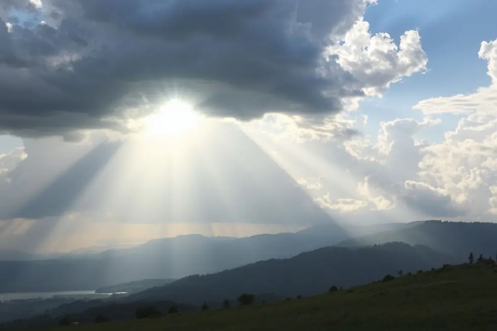 Sol iluminando uma paisagem tranquila, representando renovação espiritual.